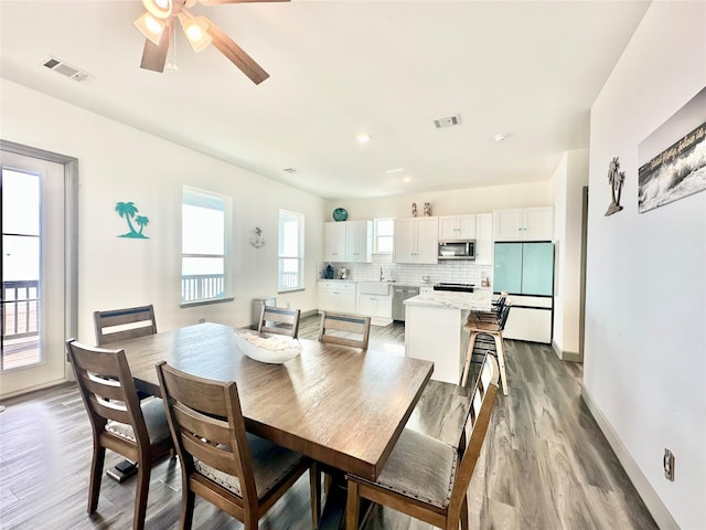 dining room with visible vents, light wood-style flooring, and ceiling fan