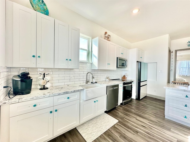 kitchen featuring a sink, tasteful backsplash, appliances with stainless steel finishes, and white cabinetry