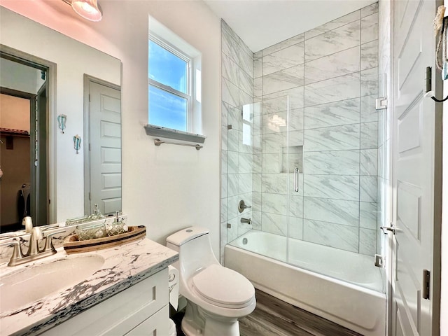 full bath with enclosed tub / shower combo, toilet, and vanity