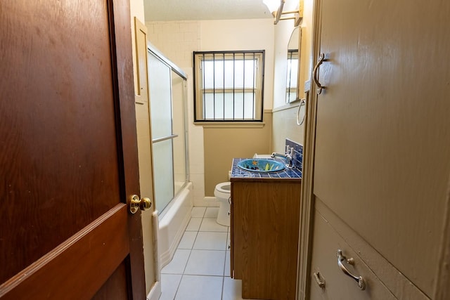 1922 Tabor St, Houston, TX 77009 - bathroom with tile patterned floors, toilet, shower / bath combination with glass door, and vanity