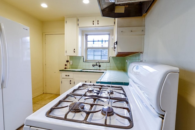 1922 Tabor St, Houston, TX 77009 - kitchen featuring white appliances, tile counters, exhaust hood, a sink, and white cabinets