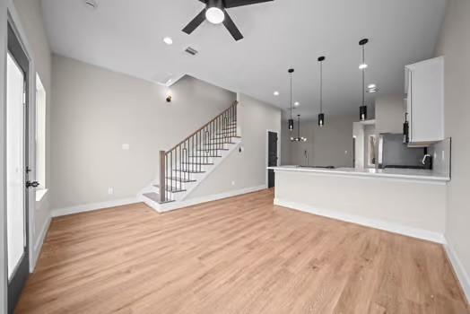 8120 Colonial Ln, Houston, TX 77051 - unfurnished living room featuring a ceiling fan, recessed lighting, stairway, light wood finished floors, and baseboards