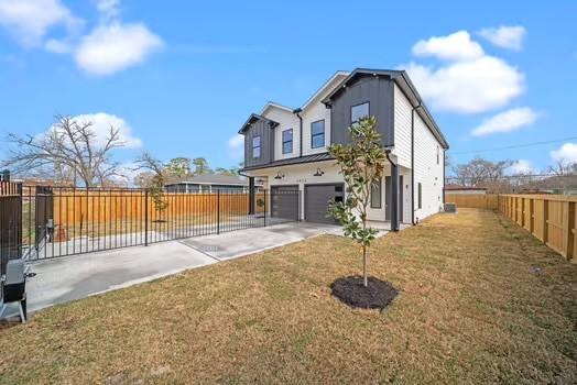 8120 Colonial Ln, Houston, TX 77051 - back of property with fence private yard, a garage, driveway, and a lawn