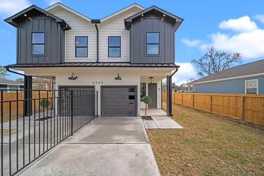 8120 Colonial Ln, Houston, TX 77051 - view of front of house with concrete driveway, an attached garage, fence, and board and batten siding