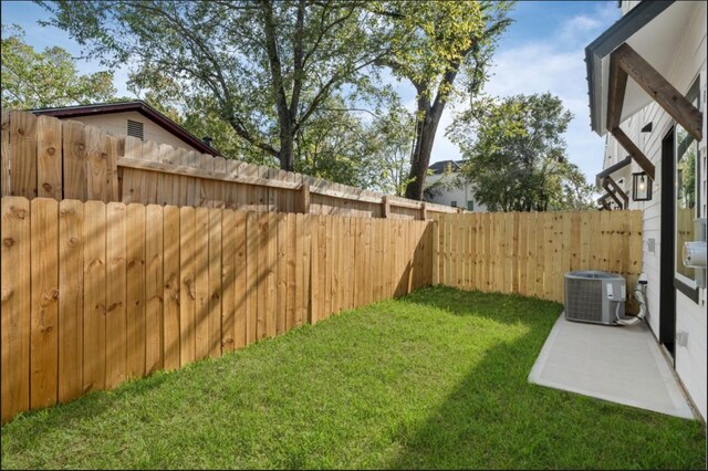 view of yard featuring central AC and a fenced backyard