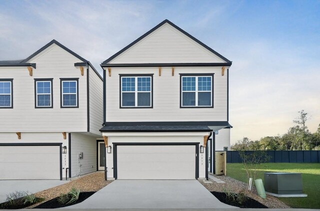view of front of house featuring a garage, a front yard, driveway, and fence