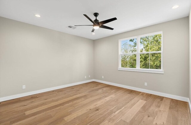spare room with visible vents, baseboards, and light wood finished floors