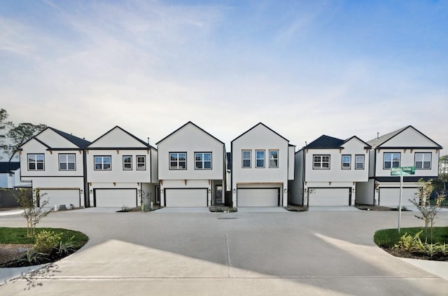 view of property featuring a residential view, driveway, and a garage