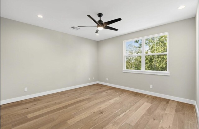 empty room featuring visible vents, baseboards, light wood-style flooring, and a ceiling fan