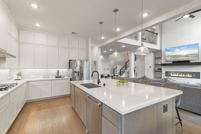 17366 Camillia Trl, Conroe, TX 77302 - kitchen featuring a sink, stainless steel appliances, open floor plan, light wood-style flooring, and recessed lighting