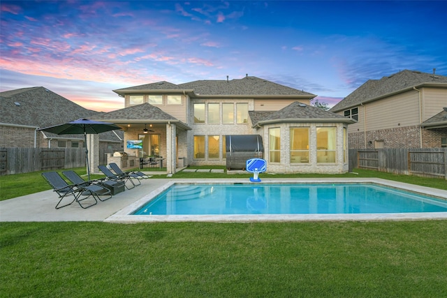 17366 Camillia Trl, Conroe, TX 77302 - back of property at dusk with a patio area, ceiling fan, brick siding, and a shingled roof