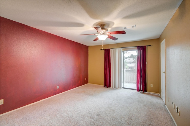 carpeted spare room featuring ceiling fan and visible vents