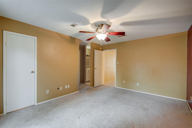 unfurnished bedroom featuring carpet flooring, a ceiling fan, visible vents, and baseboards
