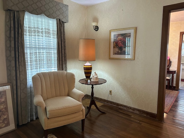living area with baseboards, hardwood / wood-style floors, and a wealth of natural light
