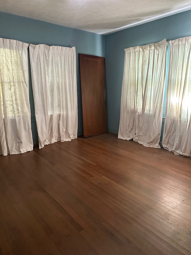 spare room with dark wood-style flooring