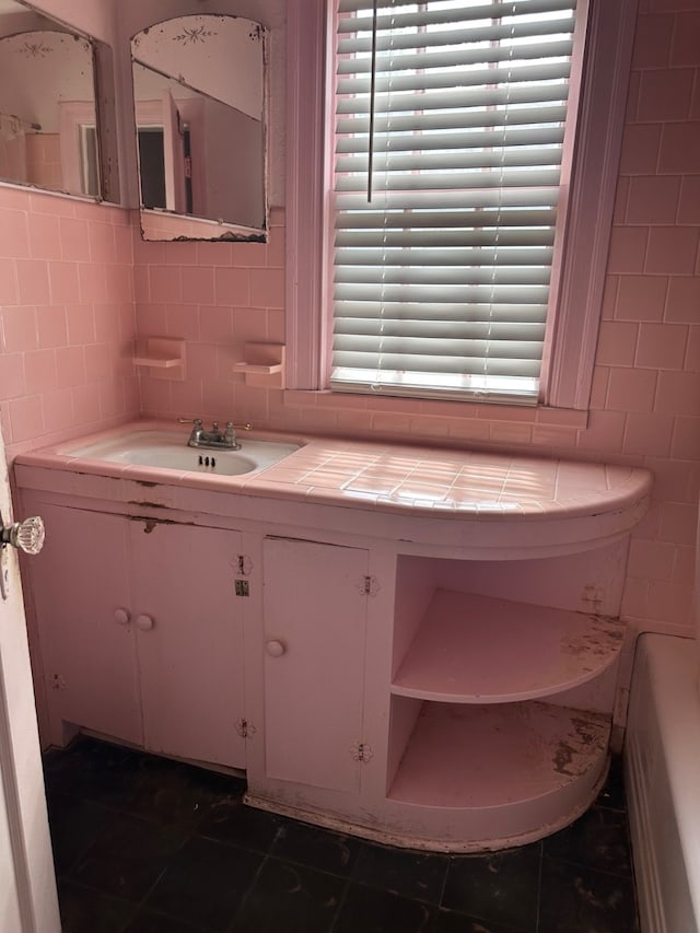 full bathroom with backsplash, a bathing tub, tile walls, and vanity