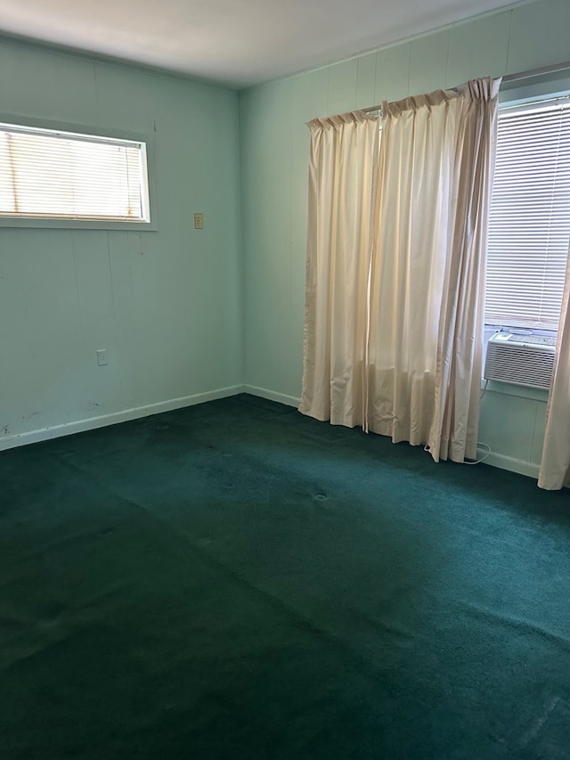 empty room featuring baseboards, cooling unit, and carpet flooring