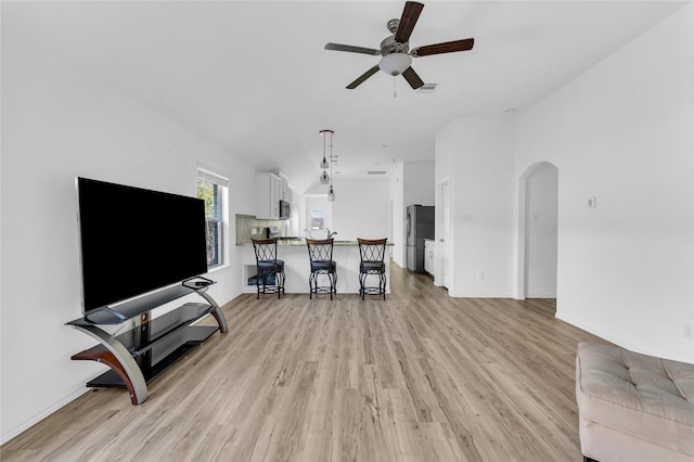 18406 Hilltop Climb Dr, Hockley, TX 77447 - living area featuring visible vents, baseboards, ceiling fan, arched walkways, and light wood finished floors