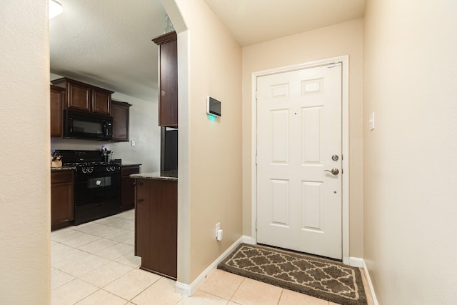 9411 Emerald Green Dr, Rosharon, TX 77583 - doorway to outside featuring arched walkways, baseboards, and light tile patterned flooring