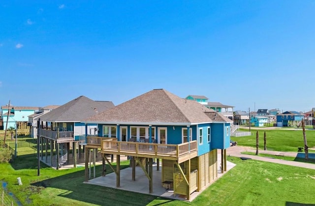 23194 Camino St, Galveston, TX 77554 - back of house with a patio, roof with shingles, a carport, a residential view, and a yard
