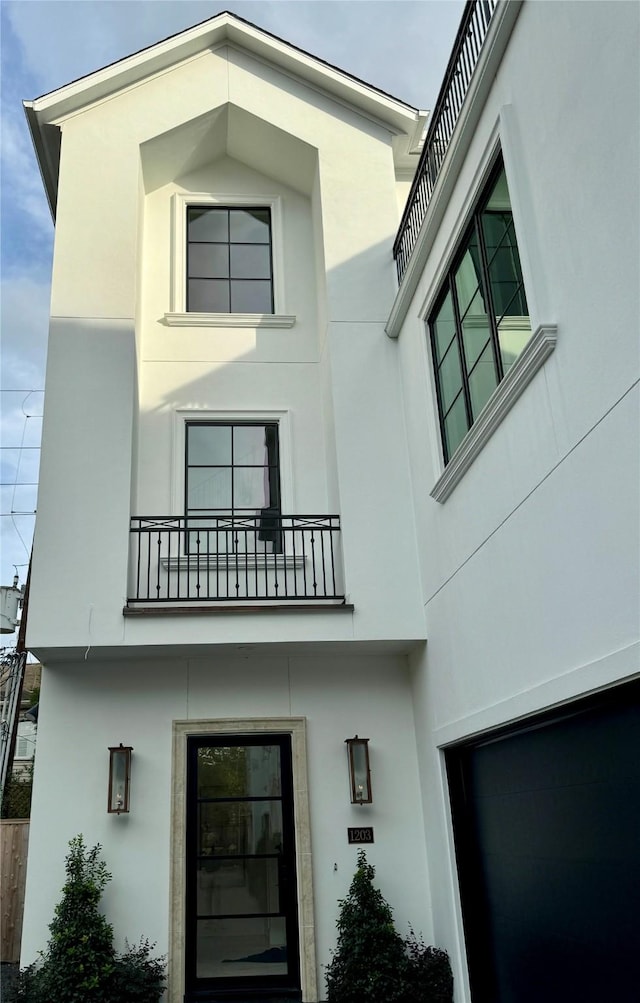 exterior space with a balcony and stucco siding