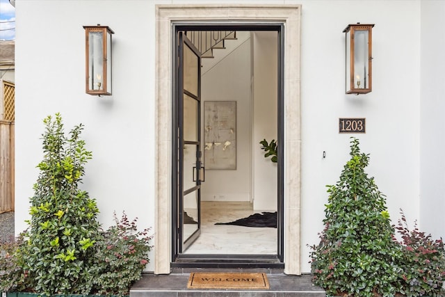 doorway to property featuring stucco siding