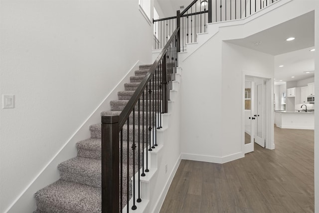 2243 Garden Arbor, Tomball, TX 77375 - staircase featuring wood finished floors, baseboards, recessed lighting, and a towering ceiling