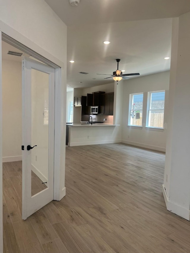 2243 Garden Arbor, Tomball, TX 77375 - unfurnished living room featuring light wood finished floors, baseboards, a ceiling fan, recessed lighting, and a sink