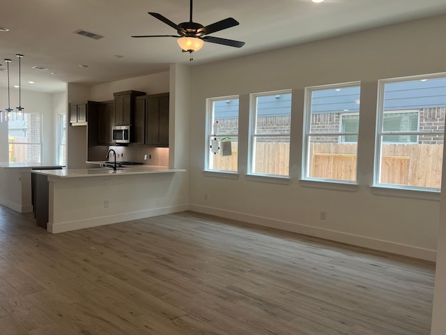 2243 Garden Arbor, Tomball, TX 77375 - kitchen featuring stainless steel microwave, light countertops, plenty of natural light, baseboards, and recessed lighting