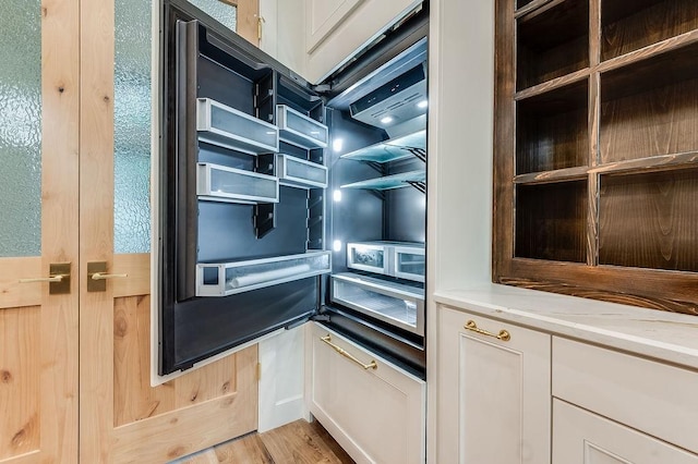 room details featuring fridge and wood finished floors