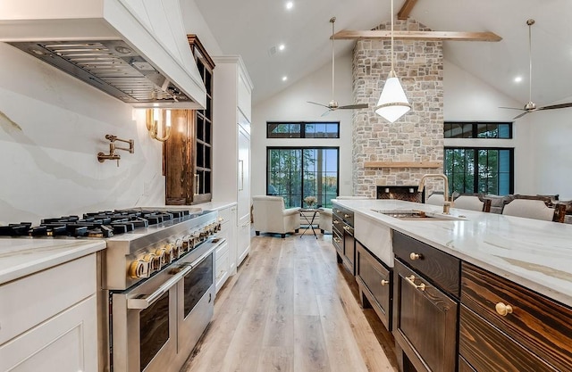 kitchen featuring open floor plan, range hood, double oven range, and ceiling fan
