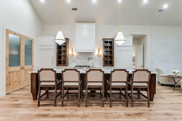 kitchen featuring a kitchen bar, tasteful backsplash, and light wood finished floors