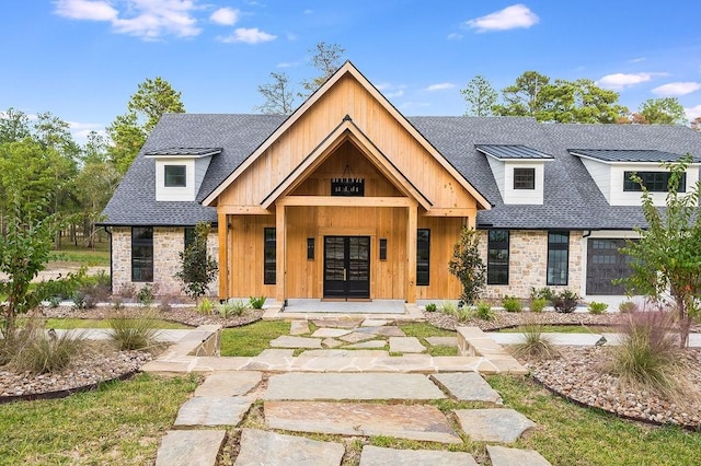 modern farmhouse featuring stone siding, french doors, and a shingled roof