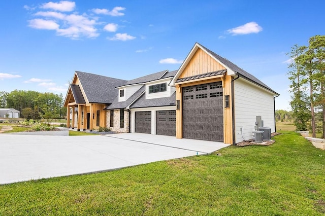 view of front of property with a front yard, a standing seam roof, a shingled roof, a garage, and central air condition unit