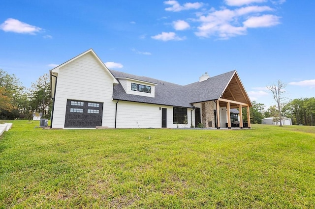 view of front of house featuring a shingled roof, a front lawn, central AC, a chimney, and an attached garage