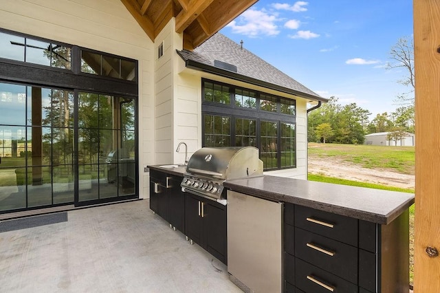 view of patio featuring exterior kitchen and a grill