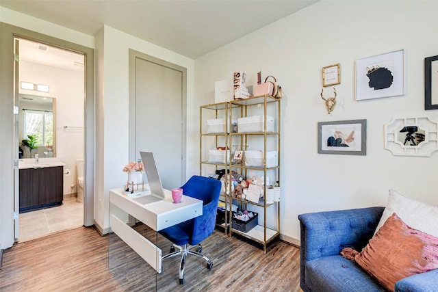 office space with baseboards and light wood finished floors