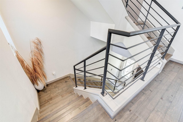staircase featuring baseboards and hardwood / wood-style floors