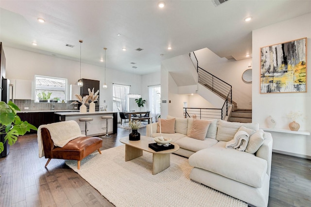 living area with stairway, recessed lighting, wood finished floors, and visible vents