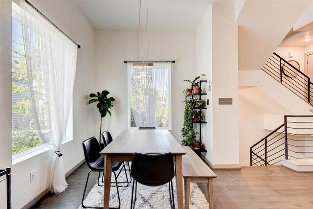 dining space with stairway, baseboards, and wood finished floors