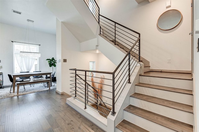 staircase featuring visible vents, baseboards, and wood finished floors