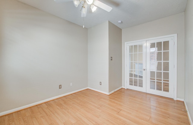 unfurnished room with baseboards, light wood-style floors, and french doors