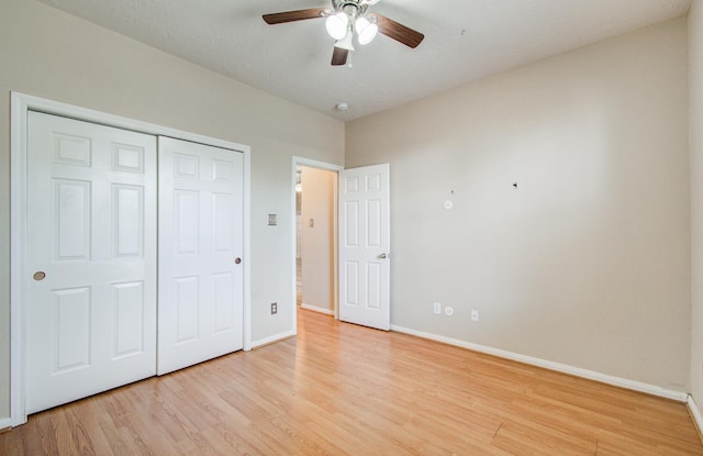 unfurnished bedroom with baseboards, a closet, light wood-style floors, and a ceiling fan