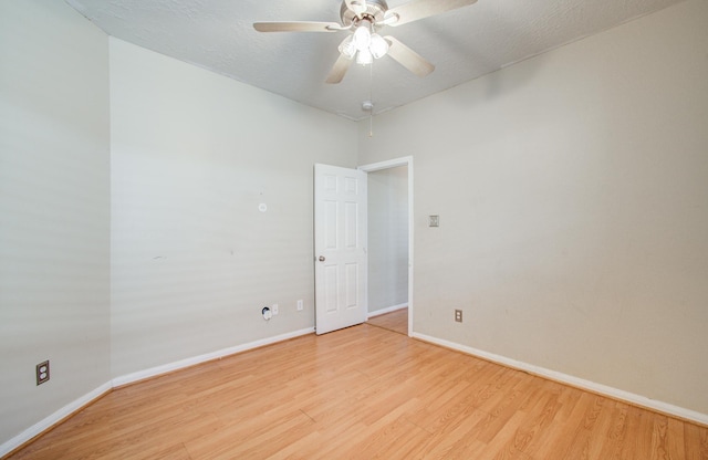unfurnished room featuring a textured ceiling, baseboards, light wood finished floors, and ceiling fan