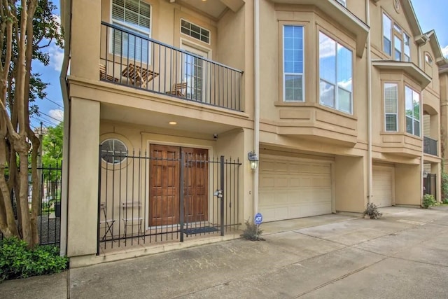 207 Knox St, Houston, TX 77007 - exterior space with a balcony, stucco siding, a garage, and fence