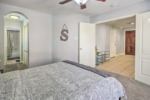 207 Knox St, Houston, TX 77007 - bedroom with tile patterned floors, a ceiling fan, arched walkways, and ensuite bathroom