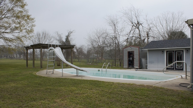 view of pool featuring fence, a yard, a water slide, an outdoor structure, and a fenced in pool