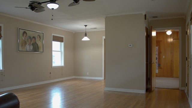 interior space with baseboards, a ceiling fan, light wood-type flooring, and ornamental molding
