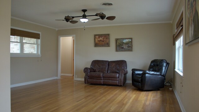 sitting room with visible vents, a healthy amount of sunlight, ceiling fan, and ornamental molding