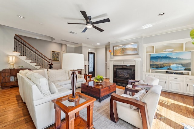 living room featuring a fireplace, recessed lighting, light wood-style floors, visible vents, and ceiling fan